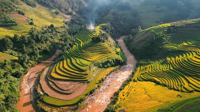 Cinematic aerial drone footage of winding rice terraces in Mu Cang Chai, Vietnam. Mountain farming landscape reveals flowing patterns shaped by traditional agriculture
