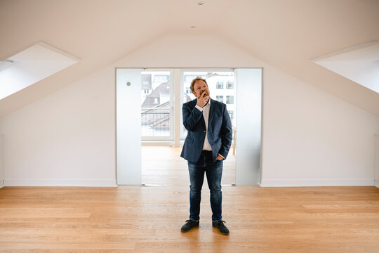 Businessman standing in empty apartement looking around