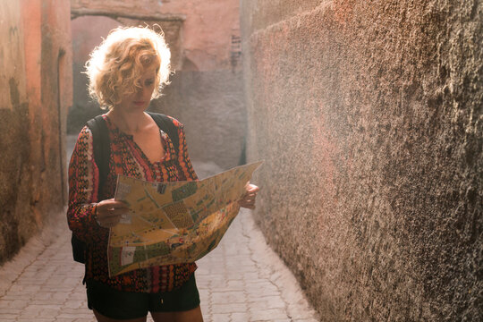 Morocco, Marrakesh, tourist standing in a passageway looking at map