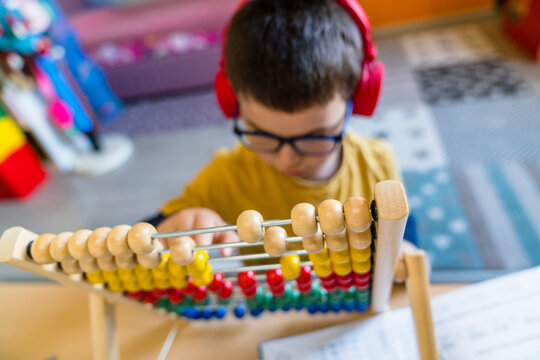 Boy calculating with abacus while sitting at home