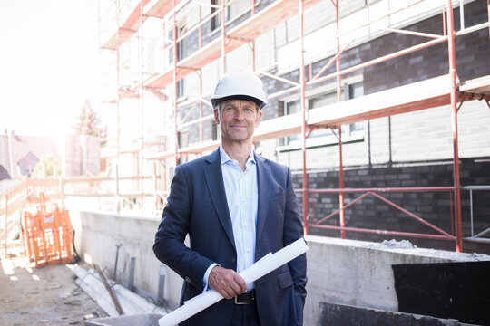 Portrait of confident architect wearing hard hat on construction site