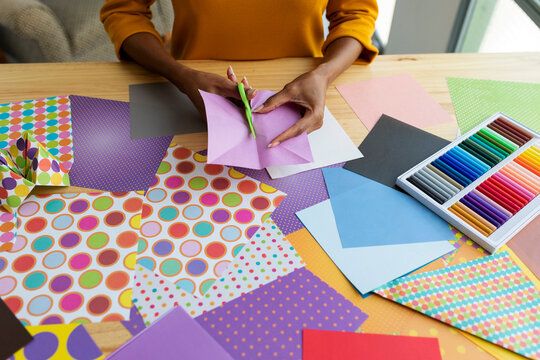 Origami artist sitting in studio folding colorful paper