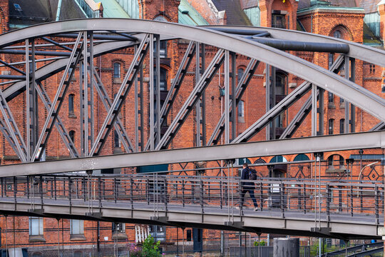 Steel bridge walkway texture meeting brick warehouse architecture in Speicherstadt portraying Hamburg Germany urban heritage with industrial detail and strong lines