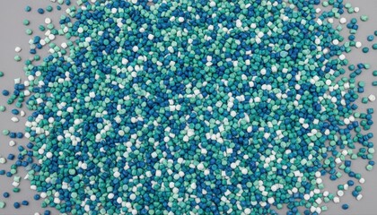 Fototapeta premium Vibrant blue and green confetti on gray background, colorful sprinkles scattered