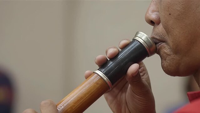 Male Adult Playing Traditional Bamboo Musical Instrument Close-Up
