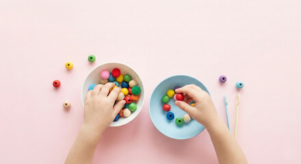 Child's hands sorting colorful wooden beads between bowls, Montessori fine motor skills development