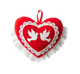 A red heart-shaped pillow with white lace and two white doves on it.
