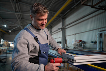 Repairman working in industrial workshop for PVC windows manufacturing