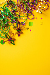 Mardi gras party poster template with beads and a fleur de lis on yellow background © photoguns