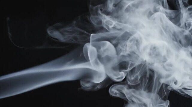 Wispy Smoke Swirls and Ebbs in Slow Motion Against a Dark Backdrop