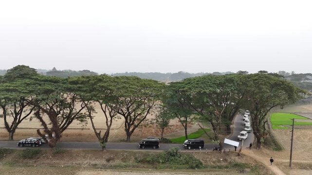 Aerial view of car convoy traveling on rural road