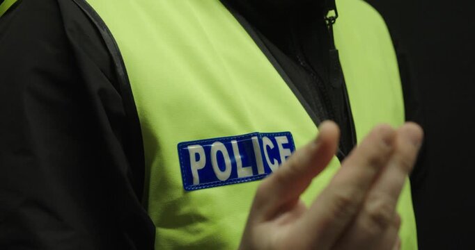 Close-up of a police officer making a money gesture, implying a fine or a bribe. Concept of corruption, bribery, abuse of authority, and illegal demands.