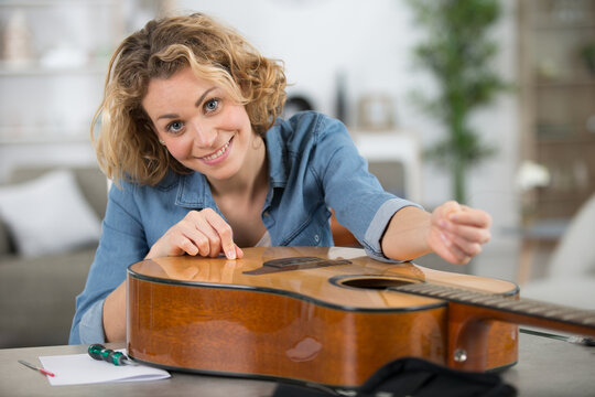 woman repairing a guitar string