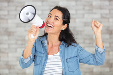 happy mature woman talking through a megaphone