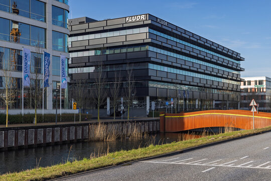 The modern Fluor office building in Hoofddorp, Netherlands, located next to a canal with a rusty bridge and Danone flags in a business district. Hoofddorp, Netherlands. 8 February 2026.