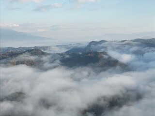 Obraz premium The sky is cloudy and the mountains are covered in fog. The clouds are low and the mountains are in the background