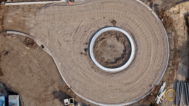 Aerial view of a newly constructed roundabout, its circular form stark against the brown earth, framed by bright concrete, Jacksonville, Florida, United States.