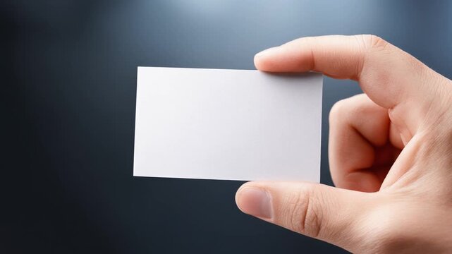 Hand holding blank business card on dark background for branding and marketing design