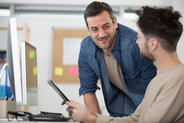 Fototapeta premium teacher working with male teenage pupil at computer