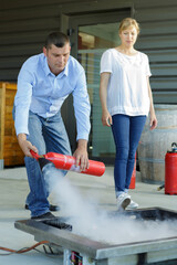 team of coworkers using fire extinguisher