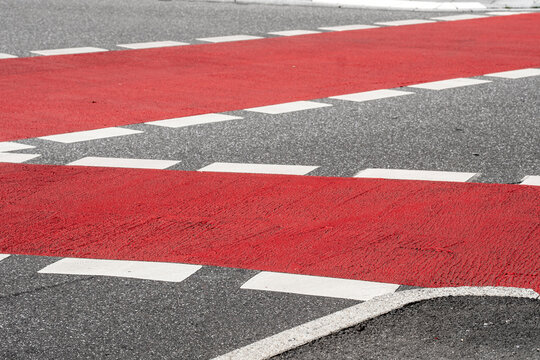 Red asphalt road bicycle bike lane crossing marking in urban Hamburg highlighting traffic guidance and safe cycling infrastructure