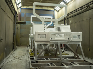 Professional industrial painter wearing white protective coverall suit and respirator mask spraying...