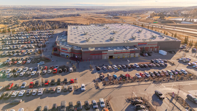 Calgary, Alberta, Canada. Feb 10, 2026. Aerial view of a large Costco Wholesale warehouse and busy parking lot at sunset.