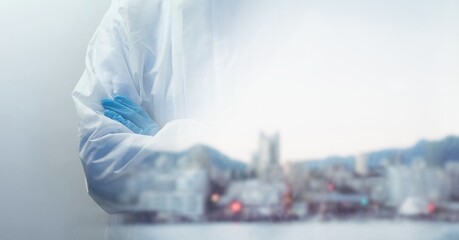Fototapeta premium Composition of midsection of person wearing ppe suit, with blurred city and copy space