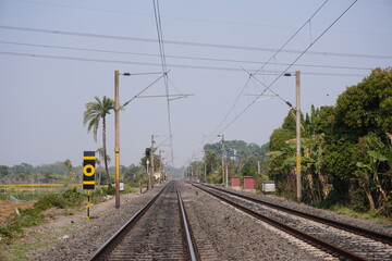 Fototapeta premium Straight Railway Track with Signal Post and Overhead Wires
