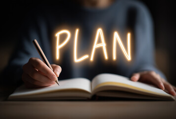 a person writing and the word "PLAN" floating above a notebook