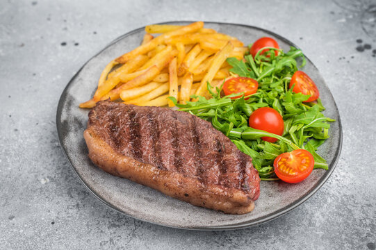 Juicy grilled beef culotte steak with potatoes and arugula salad, sirloin cap cut served for lunch or dinner