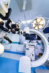 Operating room with neurosurgery microscope and overhead surgical lights. Wide shot of...