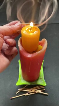 Cirio y vela con humo y llama encendido con cerilla