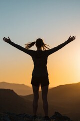 Fototapeta premium Silhouette of woman celebrating sunrise in mountain landscape