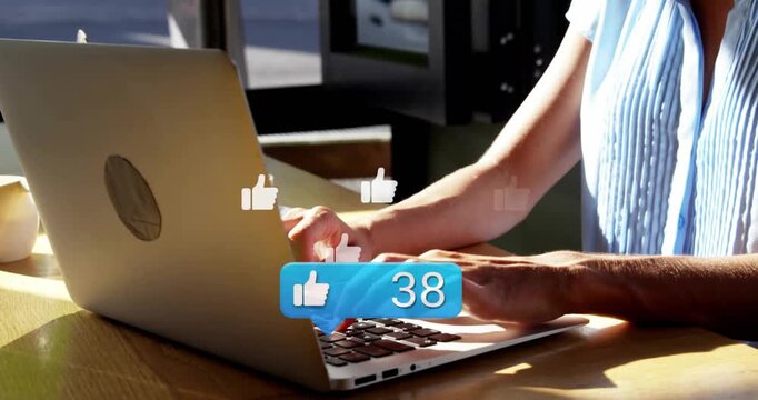 Woman typing on silver laptop in cafe, generating blue like counter rising to 77 for marketing