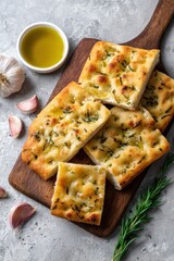Freshly baked focaccia with rosemary and garlic on wooden board
