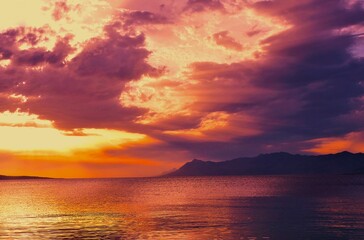 Obraz premium Heavenly colorful sunset above the sea with dramatic clouds seascape background