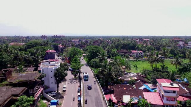 Rural area flyover with moving vehicles and greenery at colva, goa, india. day time, push in shot, drone shot, 4k.