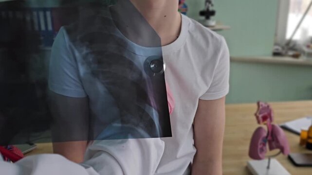 Medical professional examines patient using stethoscope while reviewing X-ray of lungs