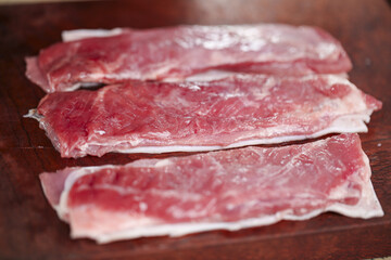 Fototapeta premium Fresh Raw Cured Meat Slices on Wood