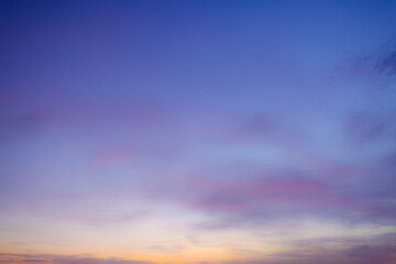 Obraz premium Beautiful Twilight Sky with Soft Pink and Blue Pastel Clouds,A serene and breathtaking view of the sunset sky, featuring a smooth gradient from deep blue to warm orange at the horizon. The soft,