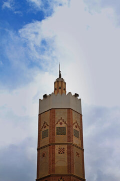 Historic Brick Minaret Tower Against Cloudy Sky in Asilah, Morocco
