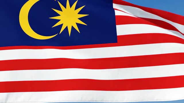 Malaysian Flag Waving Proudly in the Wind with Blue Sky Background.