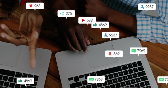 Second hand coming to two silver laptops, hands managing alerts, counts growing and rising on table