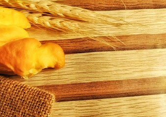 Fresh Bread with Wheat on Wooden Background