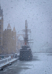 Beautiful ancient sail ship moored on the embankment of frozen Motlawa river in Gdansk