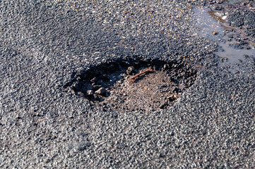 ein Schlagloch in einer Stra&szlig;e nach dem Winter