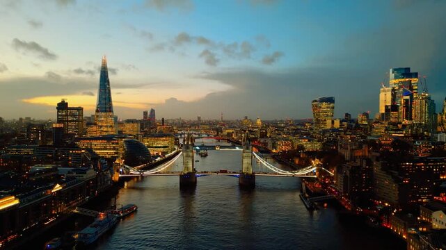 Drone aerial view of London skyline on 12 November 2025. The Shard and Tower Bridge illuminated at twilight above River Thames, vibrant city lights in cinematic 4K.