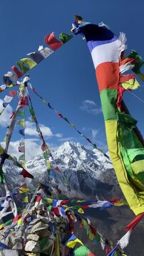 Beautiful view of Mt.Naya Kanga look through prayer flags in Langtang valley of Nepal seen from Tsergo Ri (4,990m) the high point on the Langtang valley trek of Nepal.