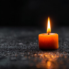 orange tiny Candle shining very small in a black Environment